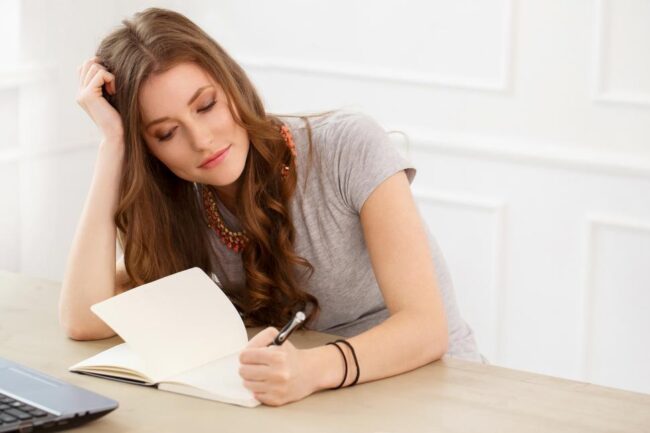 student.-attractive-girl-by-the-table-writing assignment writing tips